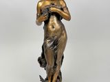 statue en bronze d'une femme tenant un oiseau sur un piédestal