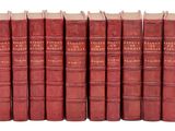 six livres rouges alignés en rangées sur une surface blanche
