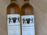 deux bouteilles de vin posées l'une à côté de l'autre sur une table en bois