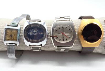 Plusieurs montres sont posées sur une serviette, sur une surface blanche.