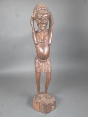 statue d'un homme coiffé d'un chapeau et tenant un morceau de bois