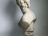 a white marble bust of a man with long hair and a beard