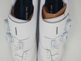 pair of white tennis shoes on a white surface with a white background