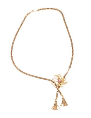 un collier en or orné d'une fleur et d'un pompon sur fond blanc
