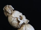 a small statue of two skulls sitting on top of each other
