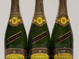 three bottles of champagne sitting on top of a white table