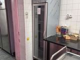 a large stainless steel refrigerator in a kitchen with pink walls