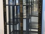 a black cabinet with glass doors in the middle of a room