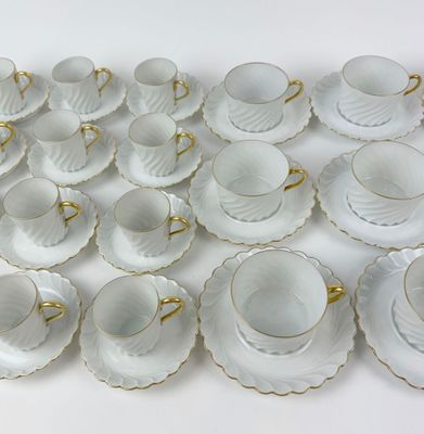 a lot of cups and saucers sitting on a table