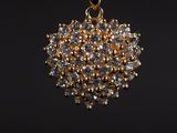 un pendentif en or orné d'un bouquet de diamants blancs sur fond noir