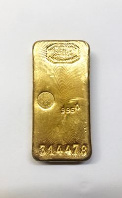 a gold bar sitting on top of a white surface