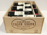 six bottles of wine in a wooden box on a table