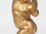 figurine en or représentant un bébé tenant une batte de baseball sur une base