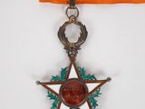 un ruban orange orné d'une étoile argentée et d'une étoile rouge