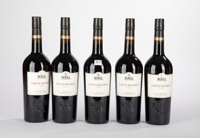 quatre bouteilles de vin sont alignées sur une surface blanche