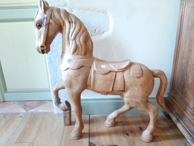 a wooden horse that is standing on a wooden floor