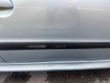 the front bumper of a silver car with a black stripe on it