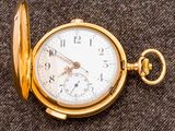 un gros plan d'une montre de poche posée sur un tissu