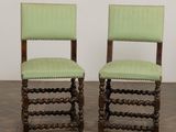 une paire de fauteuils rembourrés verts, avec des pieds en bois et une assise rembourrée verte