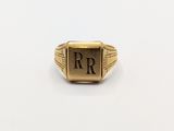 a gold signet ring with the initials r and r on it