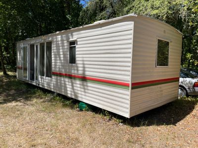 une remorque blanche avec une bande rouge et verte sur le côté