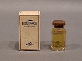 a small bottle of perfume sitting next to a box