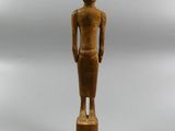 an old wooden statue of a woman standing on a wooden base