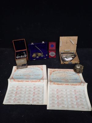 deux livres ouverts posés sur une table, avec une montre et d'autres objets