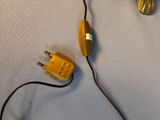 a yellow object that is connected to a black cord