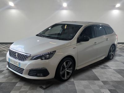 la voiture blanche est garée sur un sol en damier dans le garage