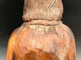 wooden sculpture of a man with a hat on top of his head