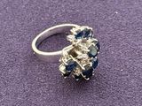 an image of a diamond and sapphire ring on a purple surface