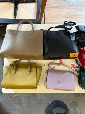 many different purses on a table in a room