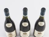 three bottles of wine sitting next to each other on a white surface