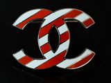 a red and white striped chanel logo pin on a black background