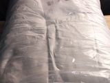 a mattress that is wrapped in plastic on a wooden table