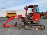 a small red excavator parked in a parking lot