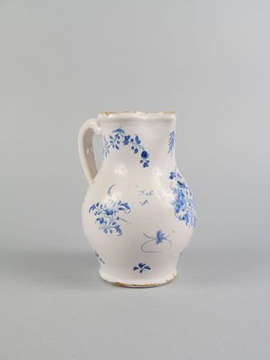 un vase bleu et blanc orné de fleurs, posé sur une surface grise