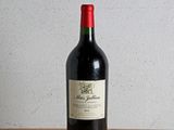 une bouteille de vin rouge posée sur une table en bois