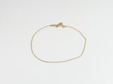 a gold chain bracelet with a tiny heart on it