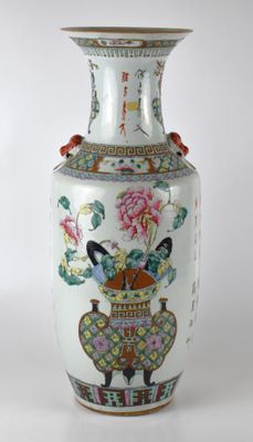 un vase orné d'un oiseau et de fleurs, posé sur une table