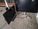 a computer monitor sitting on the floor next to a laptop