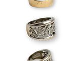 three different types of silver and gold rings on a white background