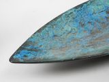 a close up of a metal object with blue paint on it