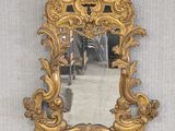 a mirror hanging on the wall with a gold frame