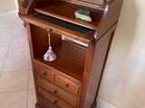 a wooden cabinet with a glass door and a blue vase on top of it