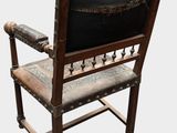 a wooden chair with a black seat and a wooden arm rest