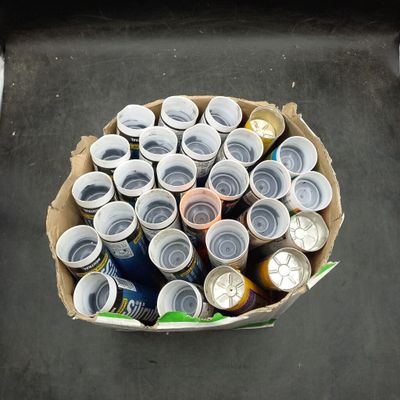 une boîte en carton remplie de canettes de bière posée par terre