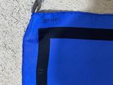 a close up of a blue and black bag on a white floor