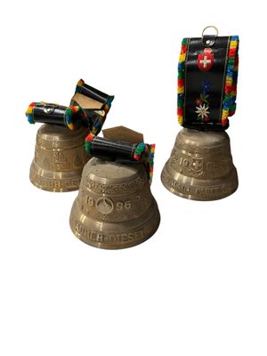 three metal bells with different designs on them sitting next to each other